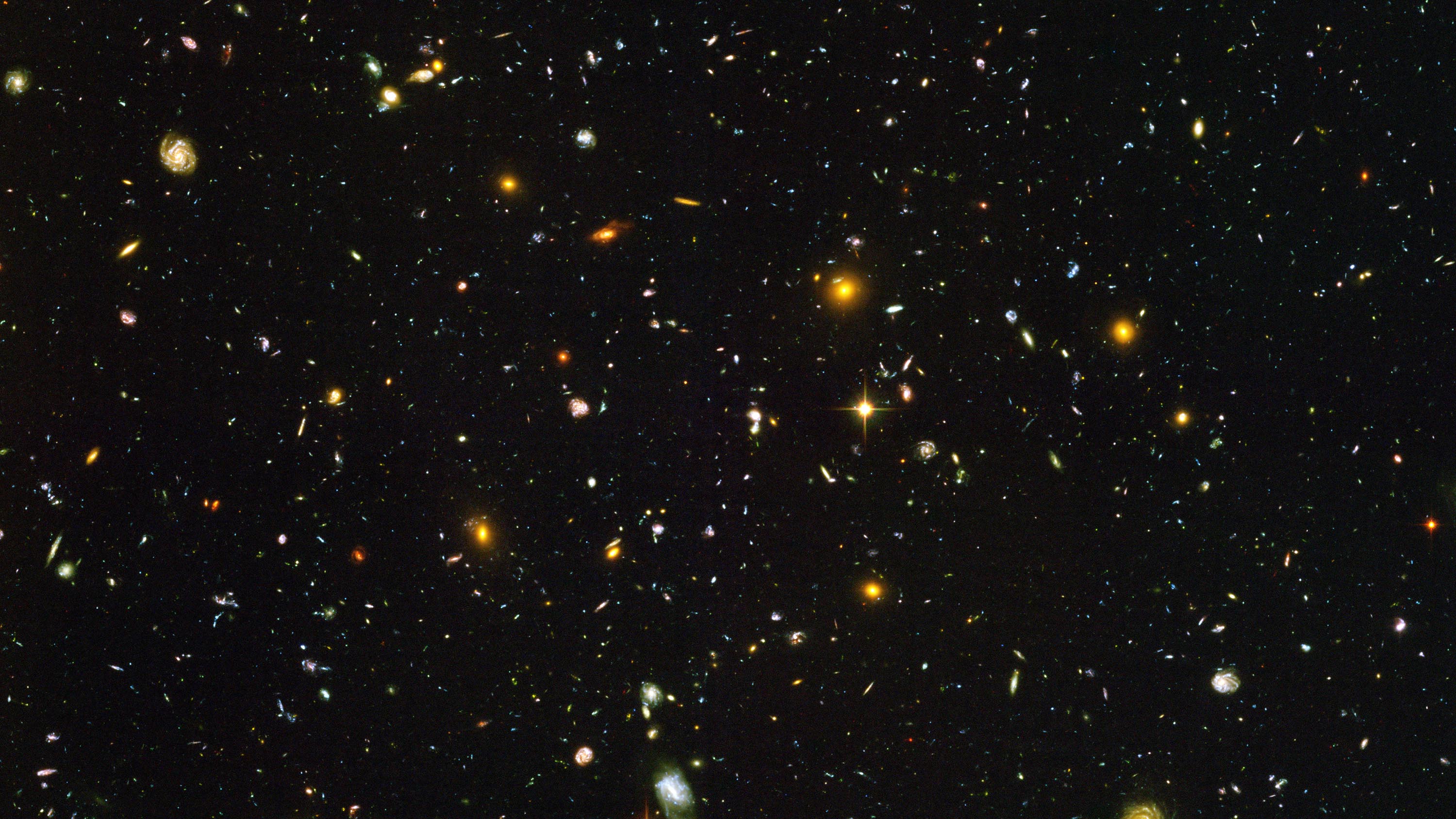 This view of nearly 10,000 galaxies is called the Hubble Ultra Deep Field. The snapshot includes galaxies of various ages, sizes, shapes, and colours. The smallest, reddest galaxies, about 100, may be among the most distant known, existing when the universe was just 800 million years old. The nearest galaxies - the larger, brighter, well-defined spirals and ellipticals - thrived about 1 billion years ago, when the cosmos was 13 billion years old. The image required 800 exposures taken over the course of 400 Hubble orbits around Earth. The total amount of exposure time was 11.3 days, taken between Sept. 24, 2003 and Jan. 16, 2004.