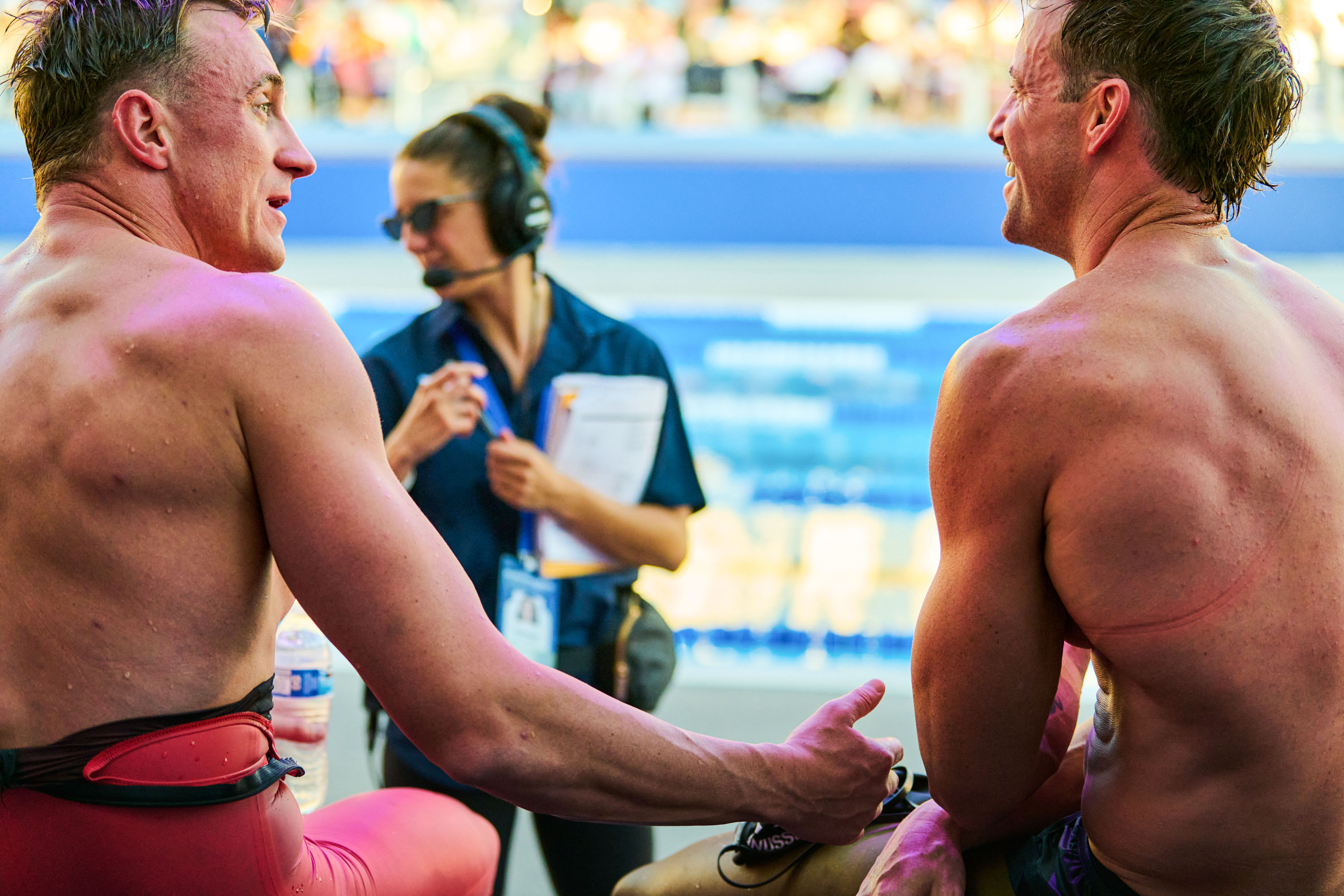 Over the shoulders of Shane Ryan (left) and James Magnussen (right) as they sit and talk poolside