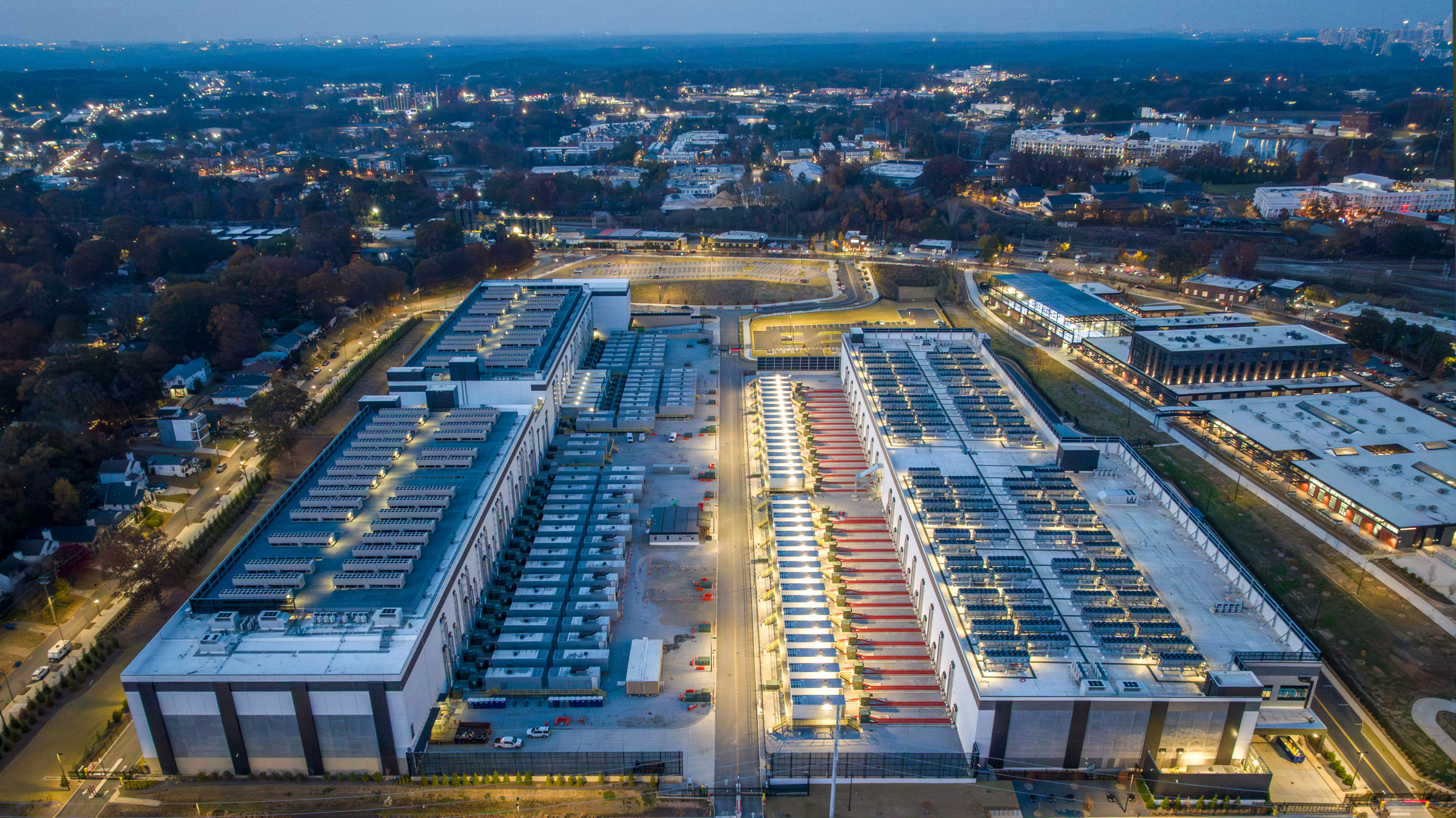 aerial view of a massive data center campus with residential neighborhoods in the distance