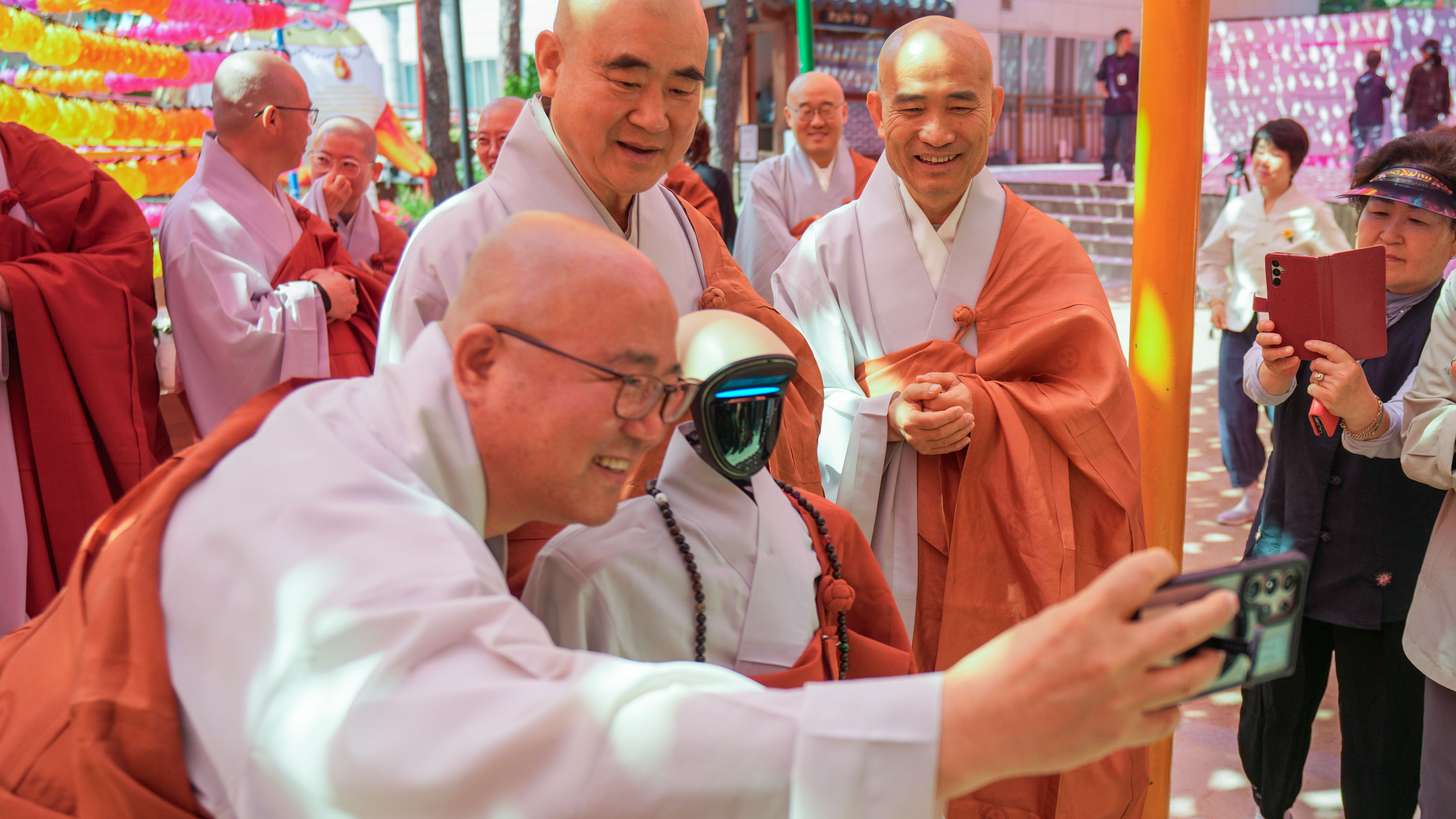 Buddhist monks take a selfie with a humanoid robot